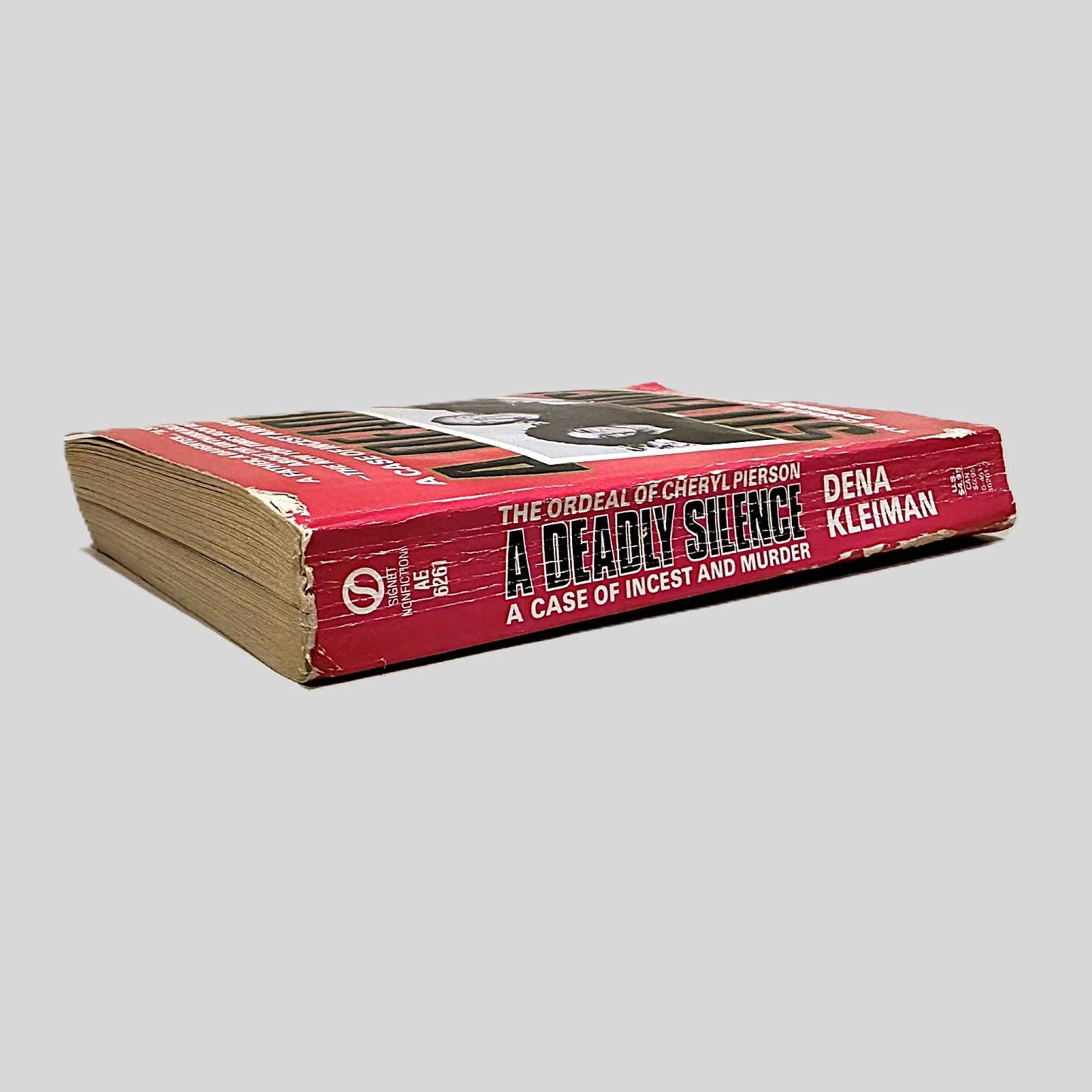 Close-up spine view of A Deadly Silence by Dena Kleiman centered on a neutral light gray background.