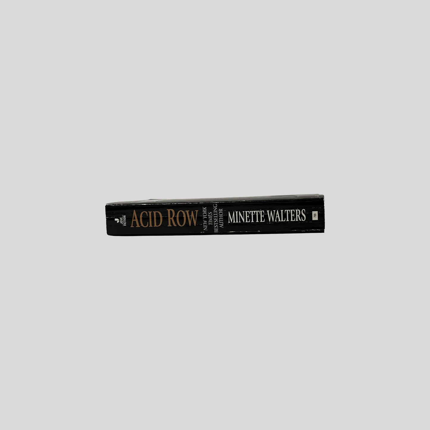 The black spine of the book "Acid Row" by Minette Walters, with the title and author's name in gold and white serif lettering and the Jove Fiction logo.