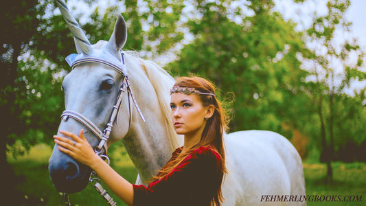 Woman with a white unicorn standing together in the Scotland Moors.