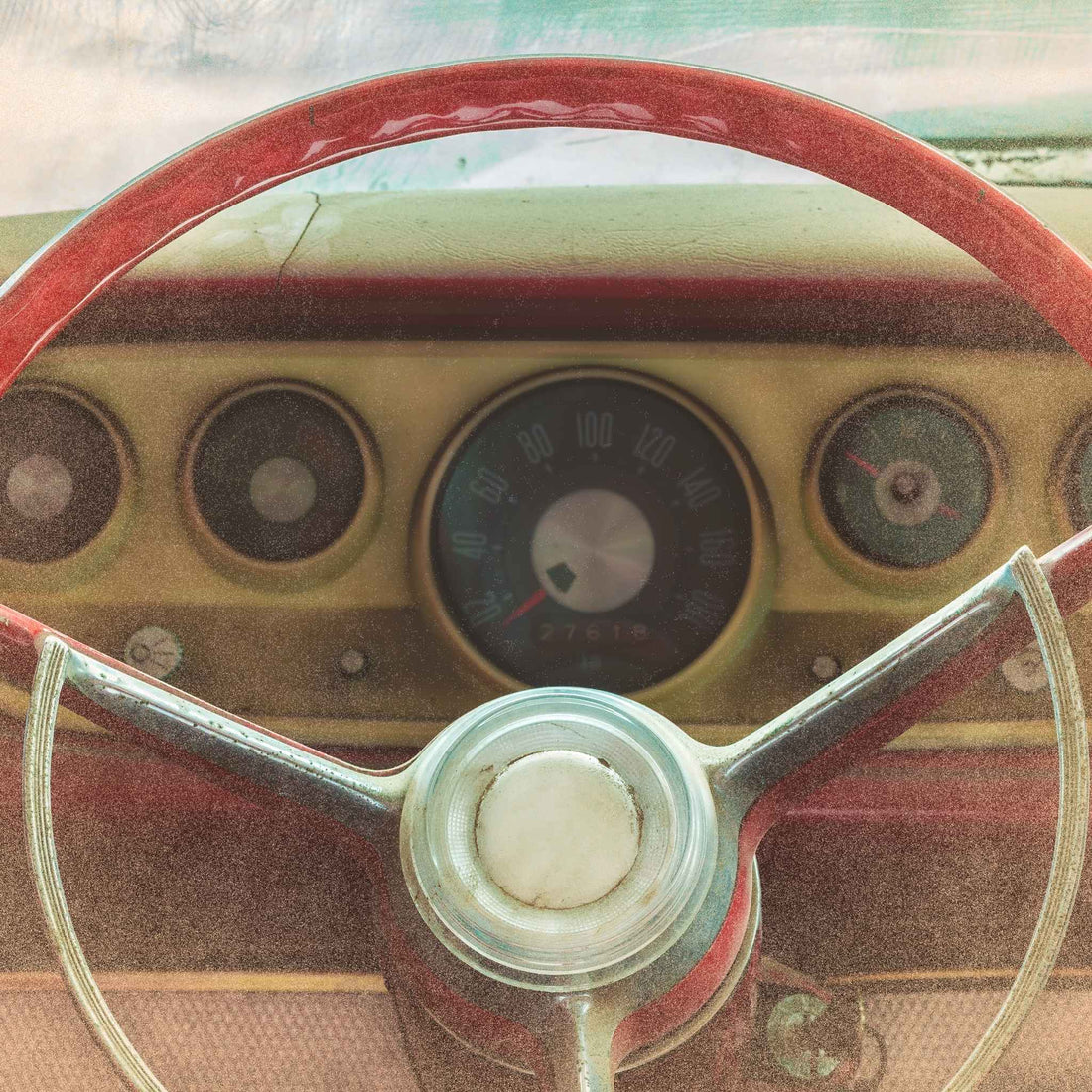 Vintage 1930's driver side interior with red steering wheel and dashboard.