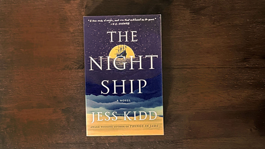 "The Night Ship" by Jess Kidd book cover featuring a sailing ship inside a yellow moon on a starry navy sky.