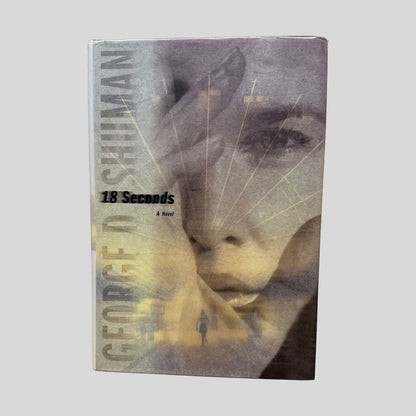 18 Seconds by George Shuman book cover. Features a blurred, atmospheric image of a face through rain-streaked glass. The author's name is in bold white and yellow lettering at the top, and the title is centered in a refined white font.