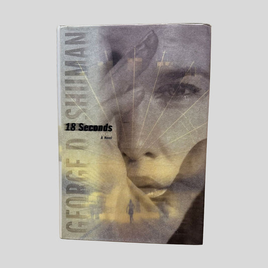 18 Seconds by George Shuman book cover. Features a blurred, atmospheric image of a face through rain-streaked glass. The author's name is in bold white and yellow lettering at the top, and the title is centered in a refined white font.