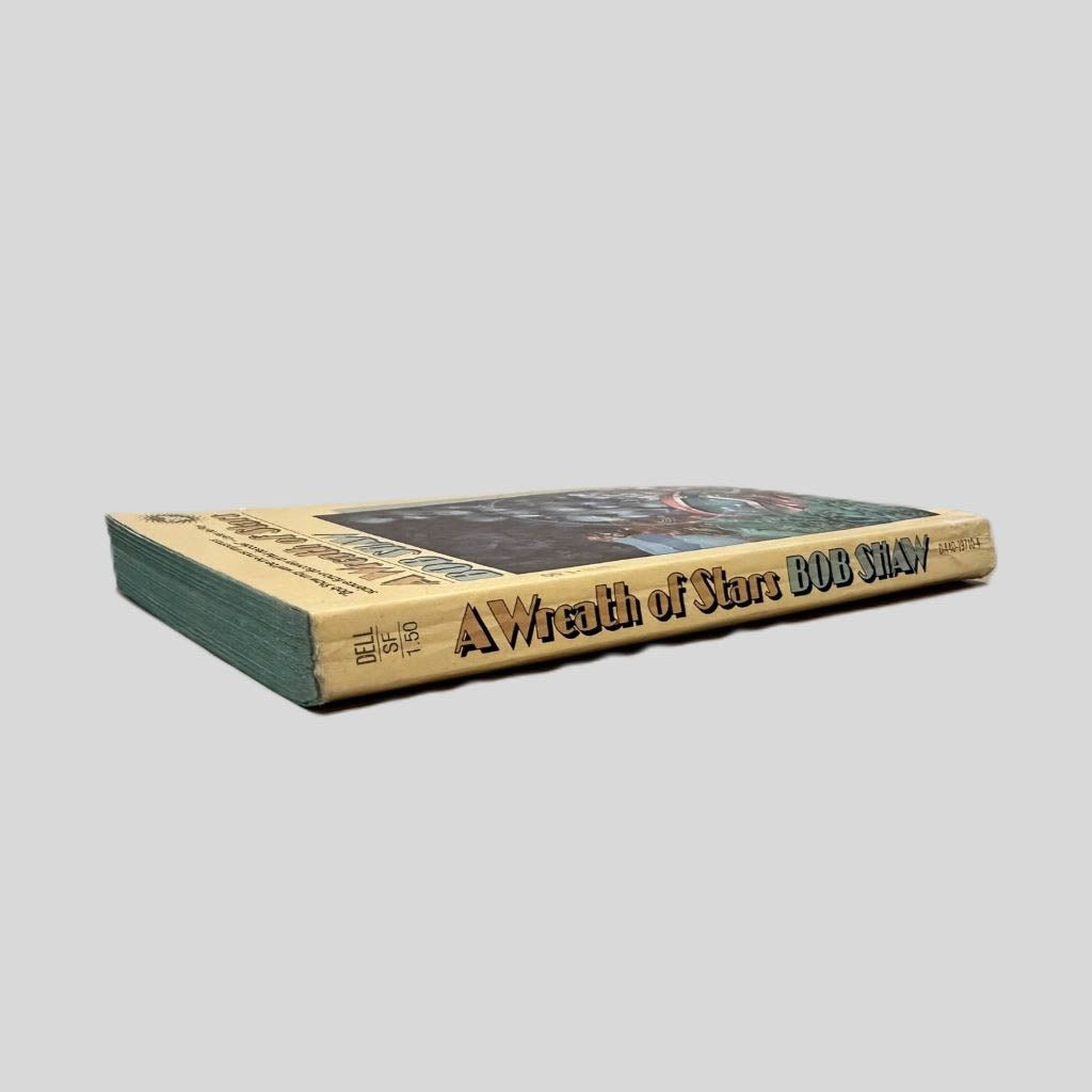 Close-up spine view of A Wreath of Stars by Bob Shaw centered on a neutral light gray background. Spine shows minimal creasing. Pages lay flat.