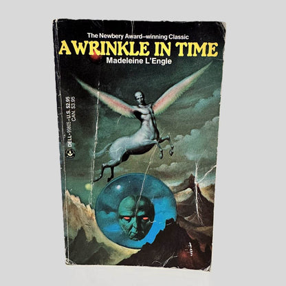 Front cover view of A Wrinkle in Time by Madeleine L'Engle centered on a neutral light gray background. Creasing and chipping present on the edges, the corners and on the cover art. The cover art coloring is vibrant.