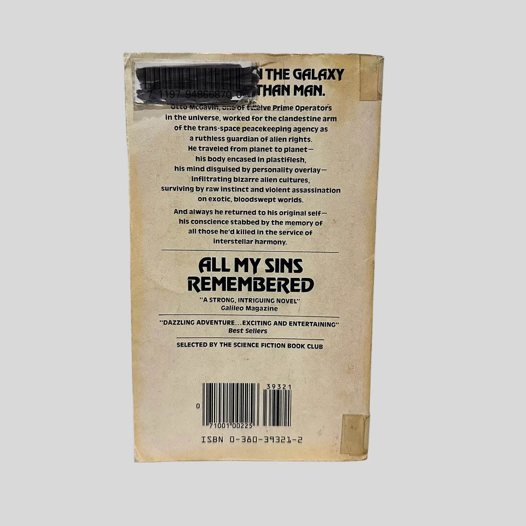 Back cover view of All My Sins Remembered by Joe Haldeman centered on a neutral light gray background. Library barcode sticker in the top right corner, colored over with black ink. Creasing and chipping are present. 