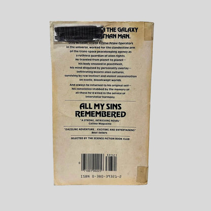 Back cover view of All My Sins Remembered by Joe Haldeman centered on a neutral light gray background. Library barcode sticker in the top right corner, colored over with black ink. Creasing and chipping are present. 
