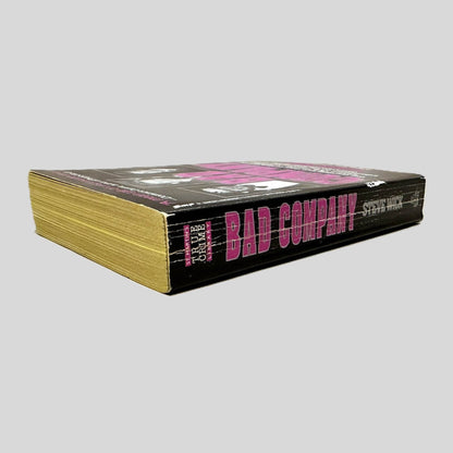 Close-up spine view of Bad Company by Steve Wick centered on a neutral light gray background. Spine is square, shows creasing.