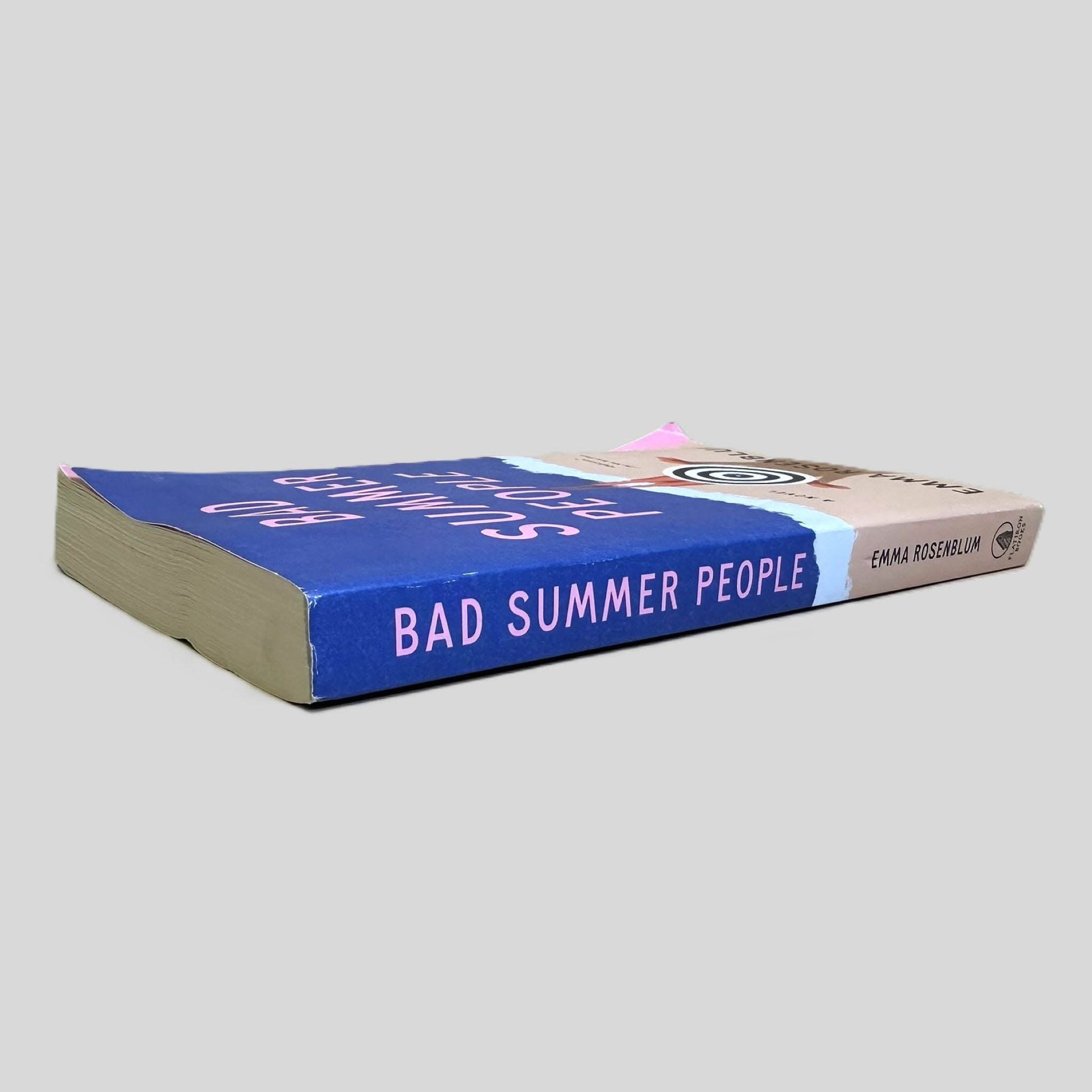 Close-up spine view of Bad Summer People by Emma Rosenblum centered on a neutral light gray background. Spine is square and shows minimal creasing.