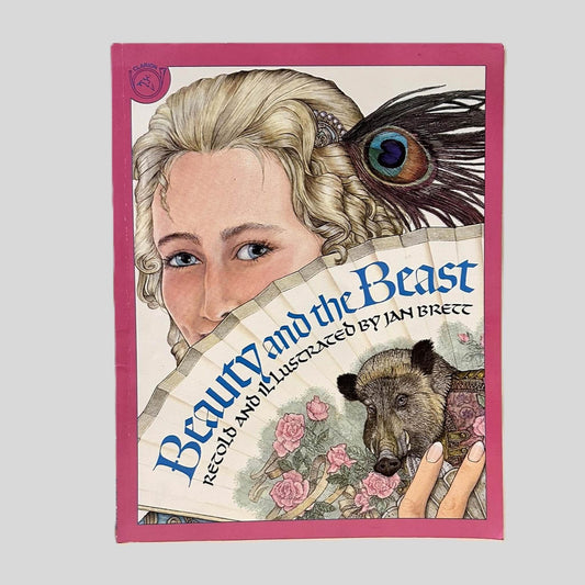 Front cover view of Beauty and the Beast Retold and Illustrated by Jan Brett centered on a neutral light gray background. Creasing near the spine and minor chipping at the corners of the cover from age.