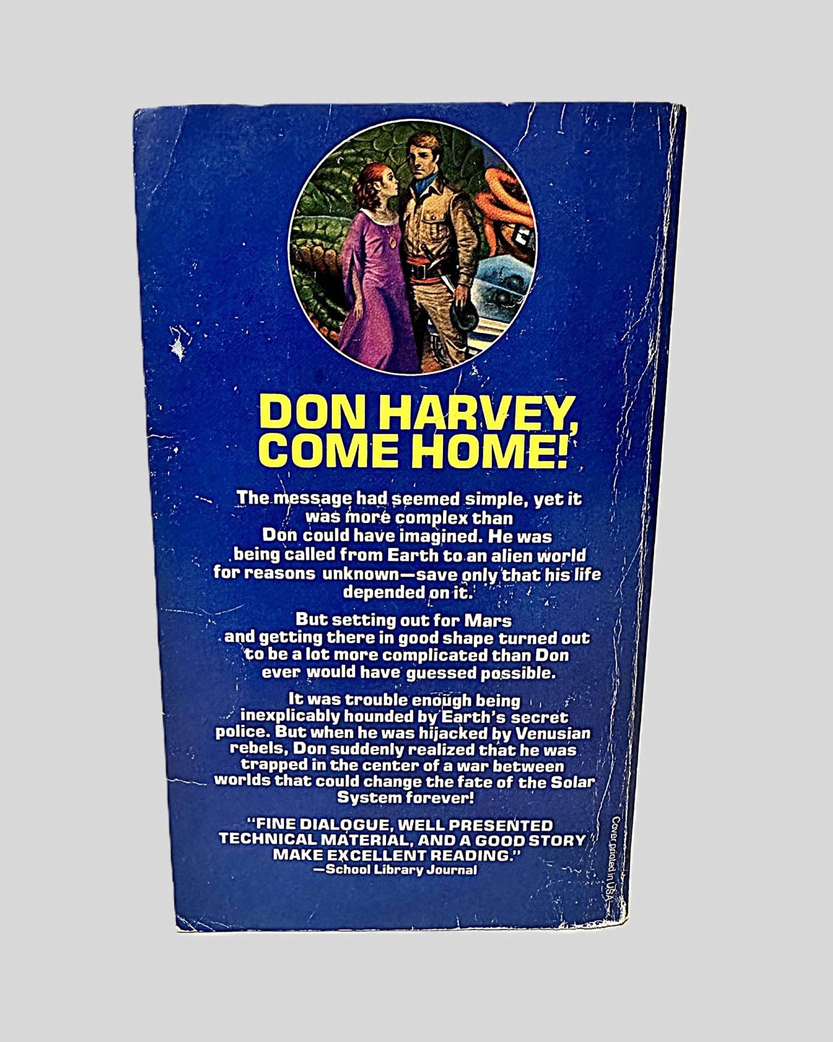 Back cover view of Between Planets by Robert A. Heinlein centered on a neutral light gray background. Creasing and chipping from wear are present around the edges and near the spine.