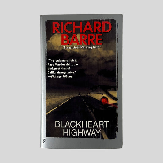 The front cover of the paperback Blackheart Highway by Richard Barre, featuring a dark photograph of a road at night with the glowing red taillights of a car in the distance.