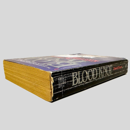 Close-up spine view of Blood Knot by David Hayes centered on a neutral light gray background. Spine shows creasing and chipping.