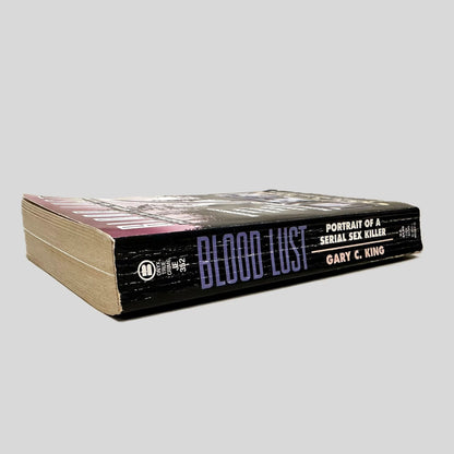 Close-up spine view of Blood Lust by Gary C. King centered on a neutral light gray background. Spine shows creasing and rubbing.