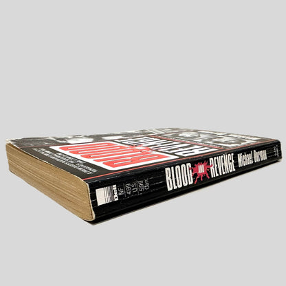 Close-up spine view of Blood and Revenge by Michael Dorman centered on a neutral light gray background. Spine shows creasing and rubbing.