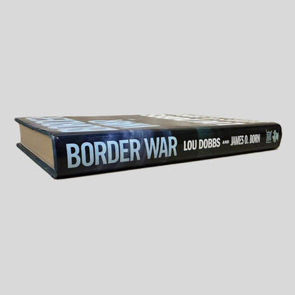 Close-up spine view of Border War by Dobbs & Born centered on a neutral light gray background. Spine shows creasing. Dust jacket is present and undamaged.