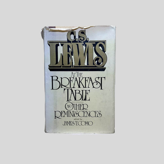 Front cover view of C.S. Lewis At the Breakfast Table Edited by James T. Como centered on a neutral light gray background. Dust jack is present. Significant tears to the top edge of the dust jacket but still intact. Hardcover behind the dust jacket does not show damage.