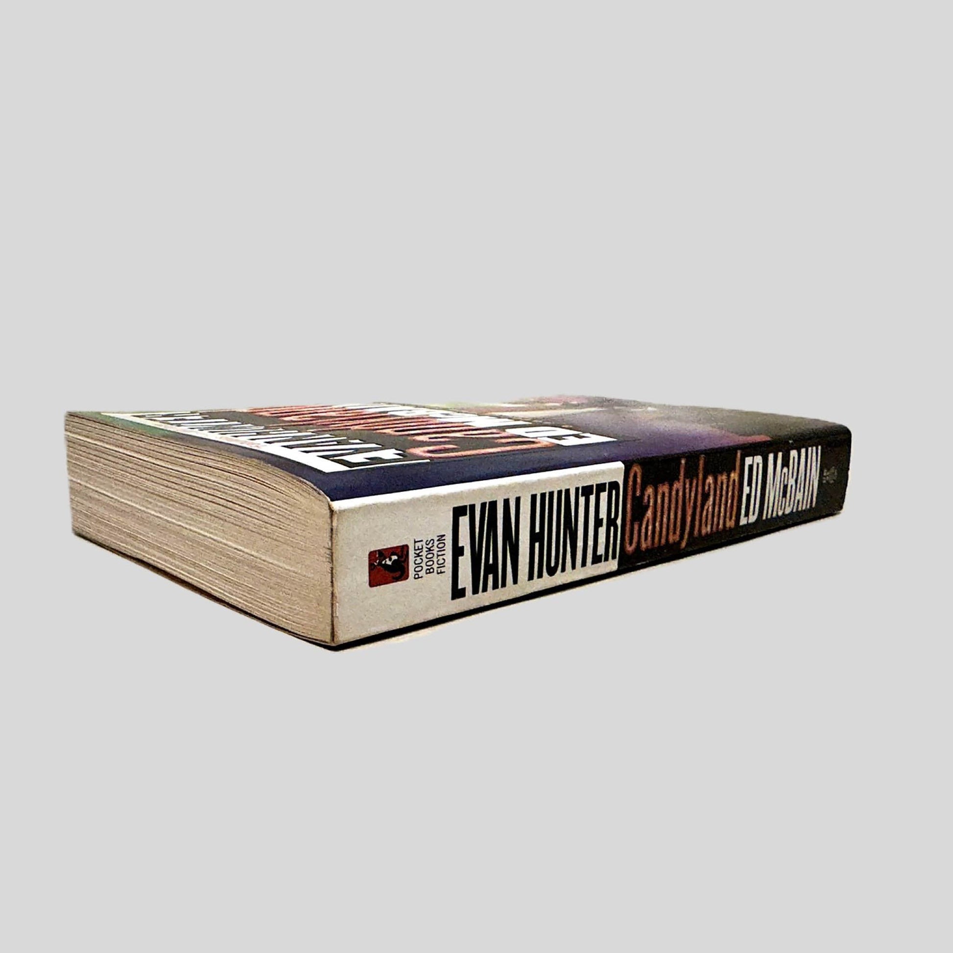 Close-up spine view of Candyland by Ed McBain centered on a neutral light gray background. Spine shows minimal creasing. Pages lay flat.