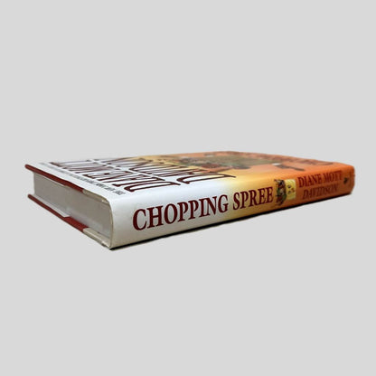 Close-up spine view of Chopping Spree by Diane Mott Davidson centered on a neutral light gray background. Dust jacket is present and undamaged. Spine shows no creasing. Pages lay flat.