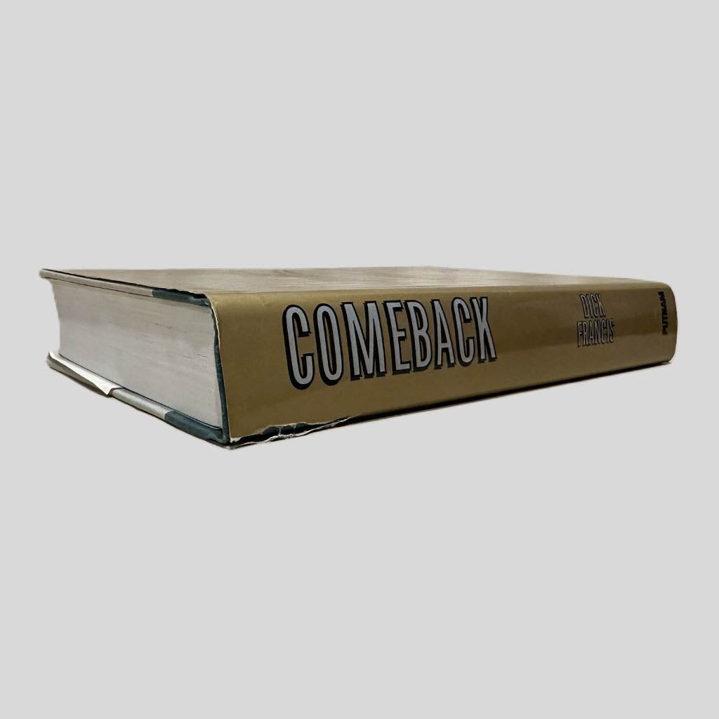 Close-up spine view of Comeback by Dick Francis centered on a neutral light gray background. Dust jacket is present and shows a tear on the bottom top of the spine. The book pages in the view lay flat.