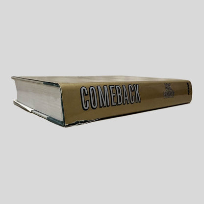 Close-up spine view of Comeback by Dick Francis centered on a neutral light gray background. Dust jacket is present and shows a tear on the bottom top of the spine. The book pages in the view lay flat.
