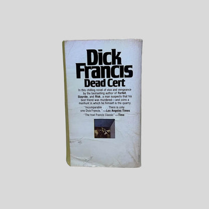 Back cover view of Dead Cert by Dick Francis centered on a neutral light gray background. Back cover shows creasing and rubbing.