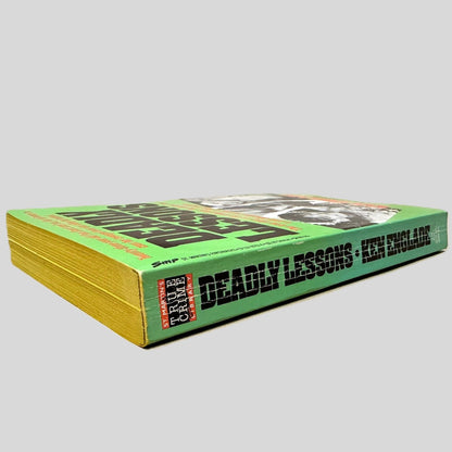 Close-up spine view of Deadly Lessons by Ken Englade centered on a neutral light gray background. Spine shows creasing.