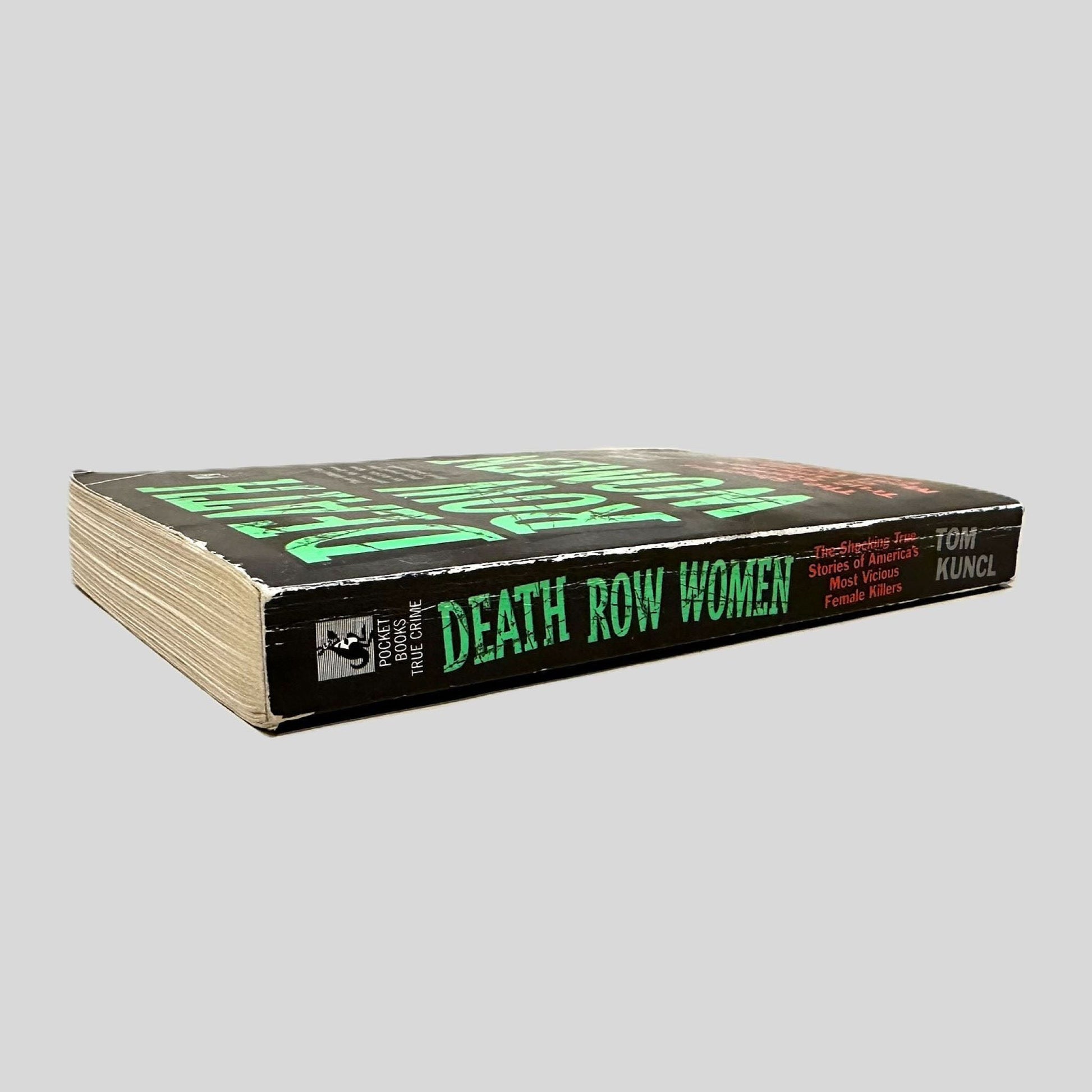 Close-up spine view of Death Row Women by Tom Kuncl centered on a neutral light gray background. Spine shows creasing and bumping.
