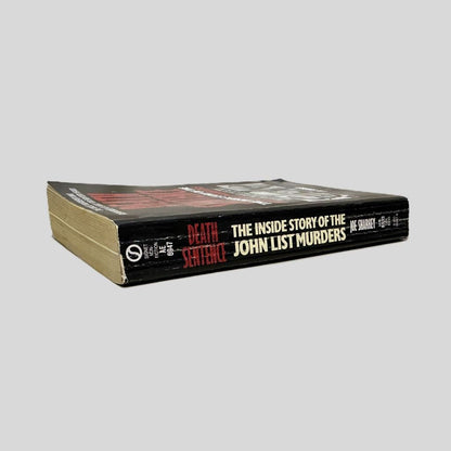 Close-up spine view of Death Sentence by Joe Sharkey centered on a neutral light gray background. Spine shows creasing and Signet logo.