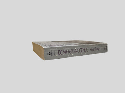 Close-up spine view of Death of Innocence by Pete Meyer centered on a neutral light gray background. Spine shows creasing and rubbing.