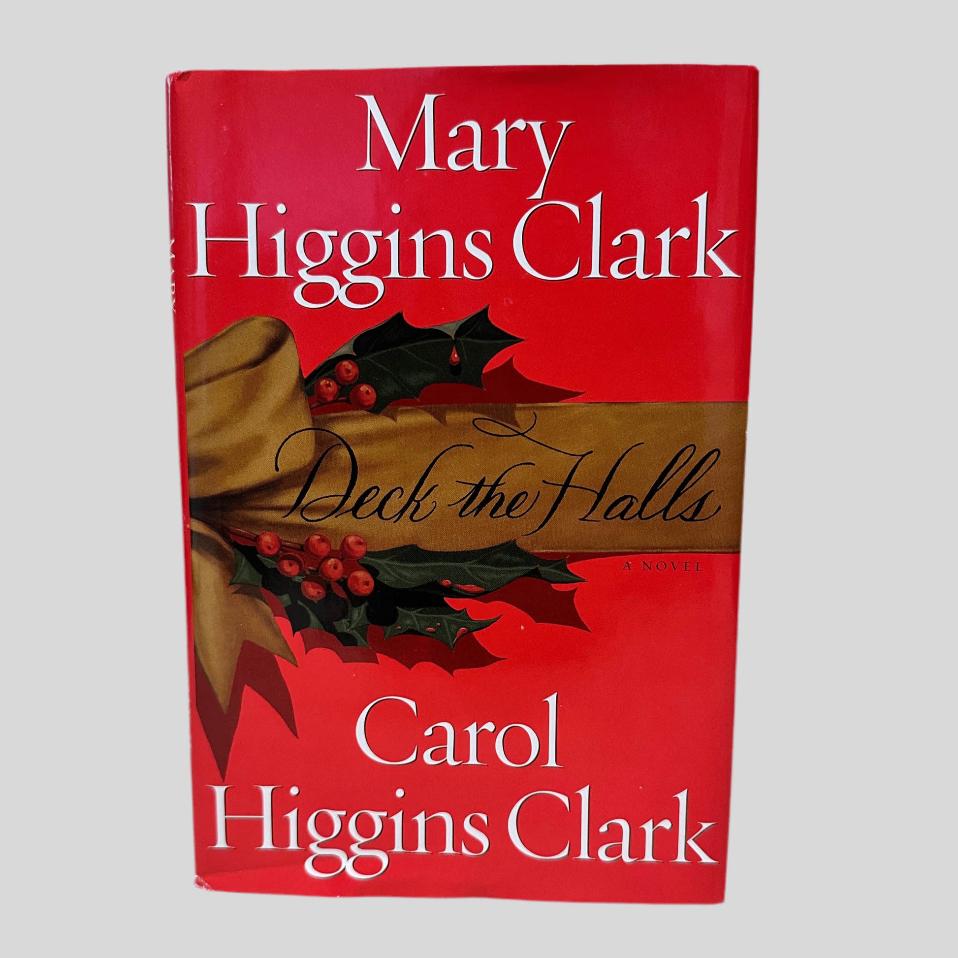 Front cover view of Deck the Halls by Mary & Carol Higgins Clark centered on a neutral light gray background. Dust jacket is present and undamaged. 