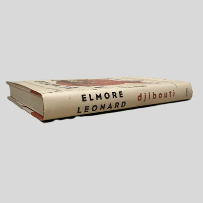 Close-up spine view of Djibouti by Elmore Leonard centered on a neutral light gray background.