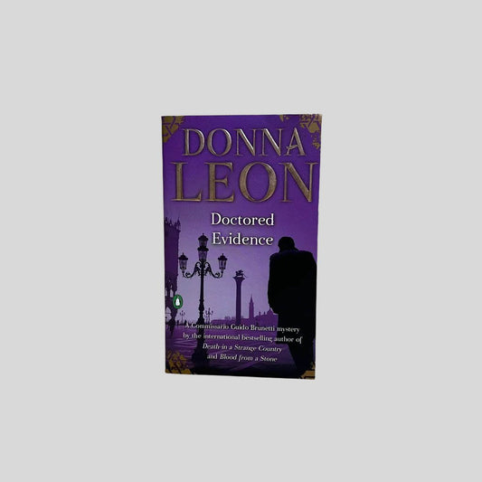 Front cover view of Doctored Evidence by Donna Leon centered on a neutral light gray background. 