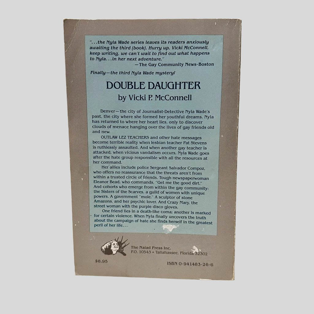 Back cover view of Double Daughter by Vicki P McConnell centered on a neutral light gray background. Creasing on the top left corner. Chipping is present along edges and spine.