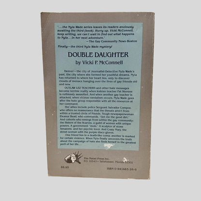 Back cover view of Double Daughter by Vicki P McConnell centered on a neutral light gray background. Creasing on the top left corner. Chipping is present along edges and spine.