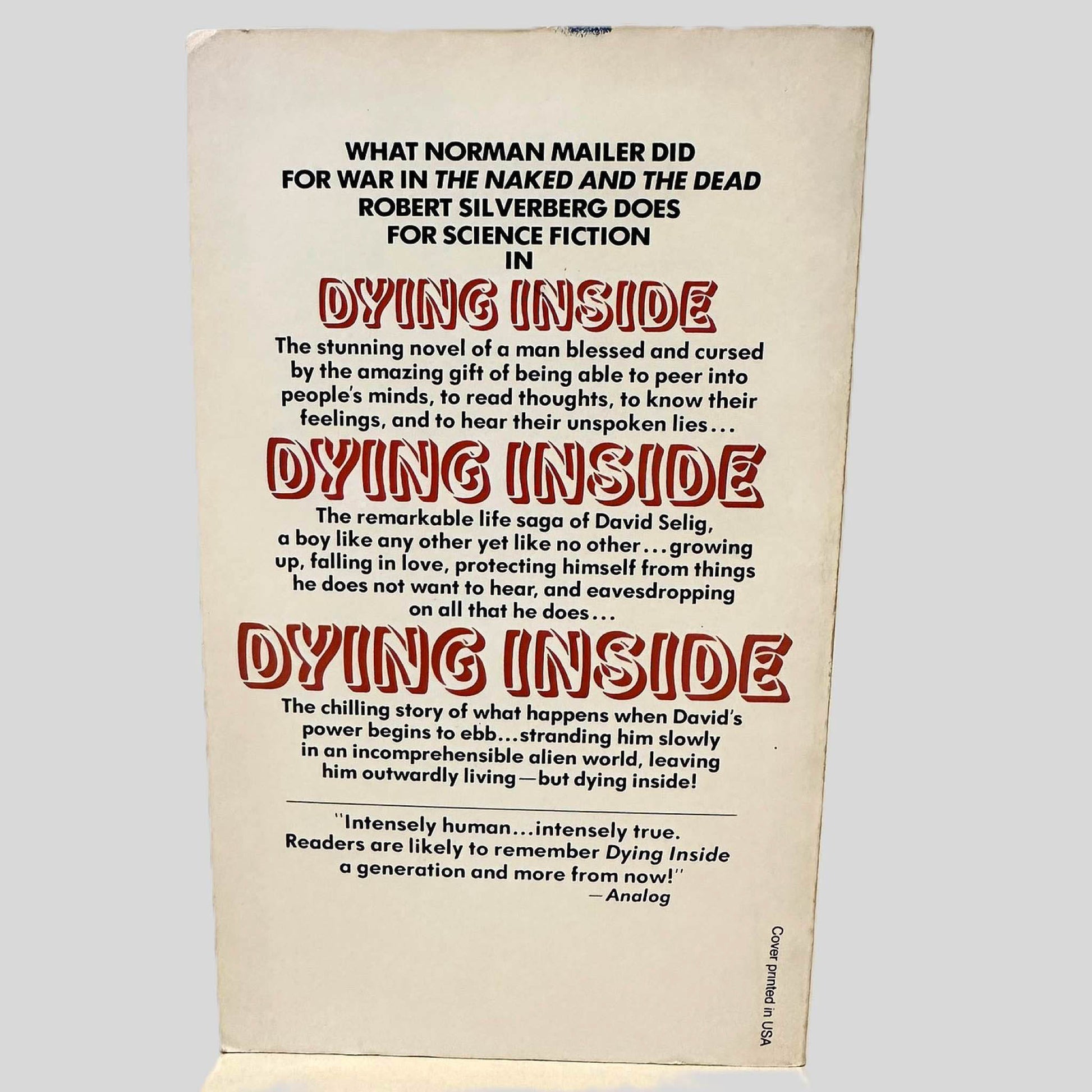 Back cover view of Dying Inside by Robert Silverberg centered on a neutral light gray background. Minor chipping is present and small crease to the tip of the top right corner.