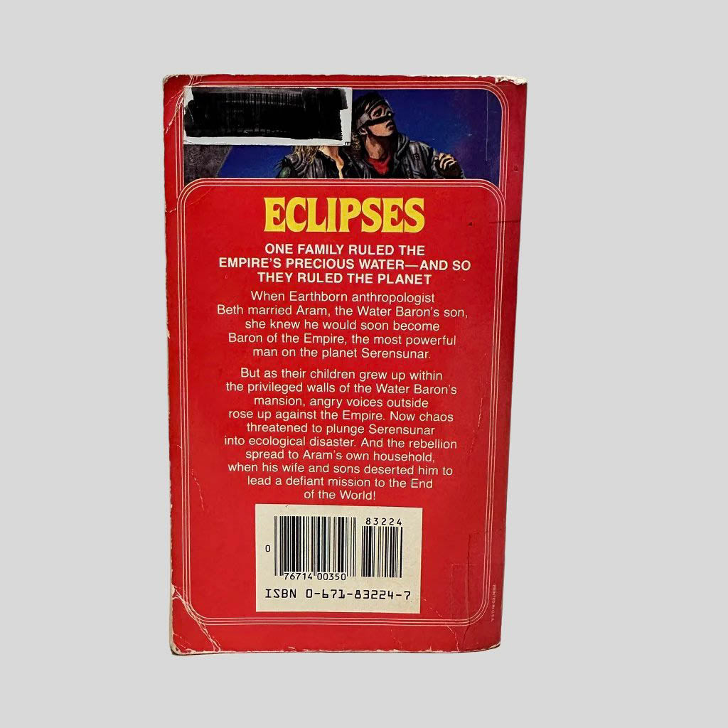 Back cover view of Eclipses by Cynthia Felice centered on a neutral light gray background. Chipping and creasing around the corners and edges. Library barcode sticker in the top left corner, colored over with black ink. 