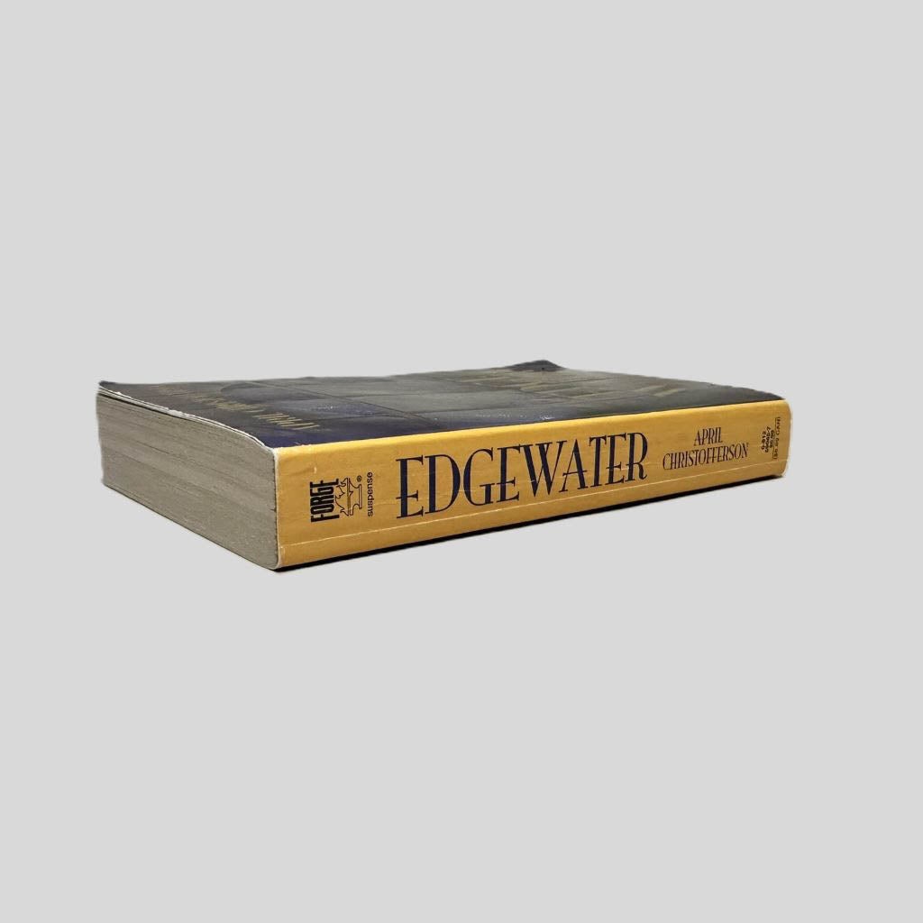 Close-up spine view of Edge Water by April Christofferson centered on a neutral light gray background. Spine shows minimal creasing. Pages lay flat.