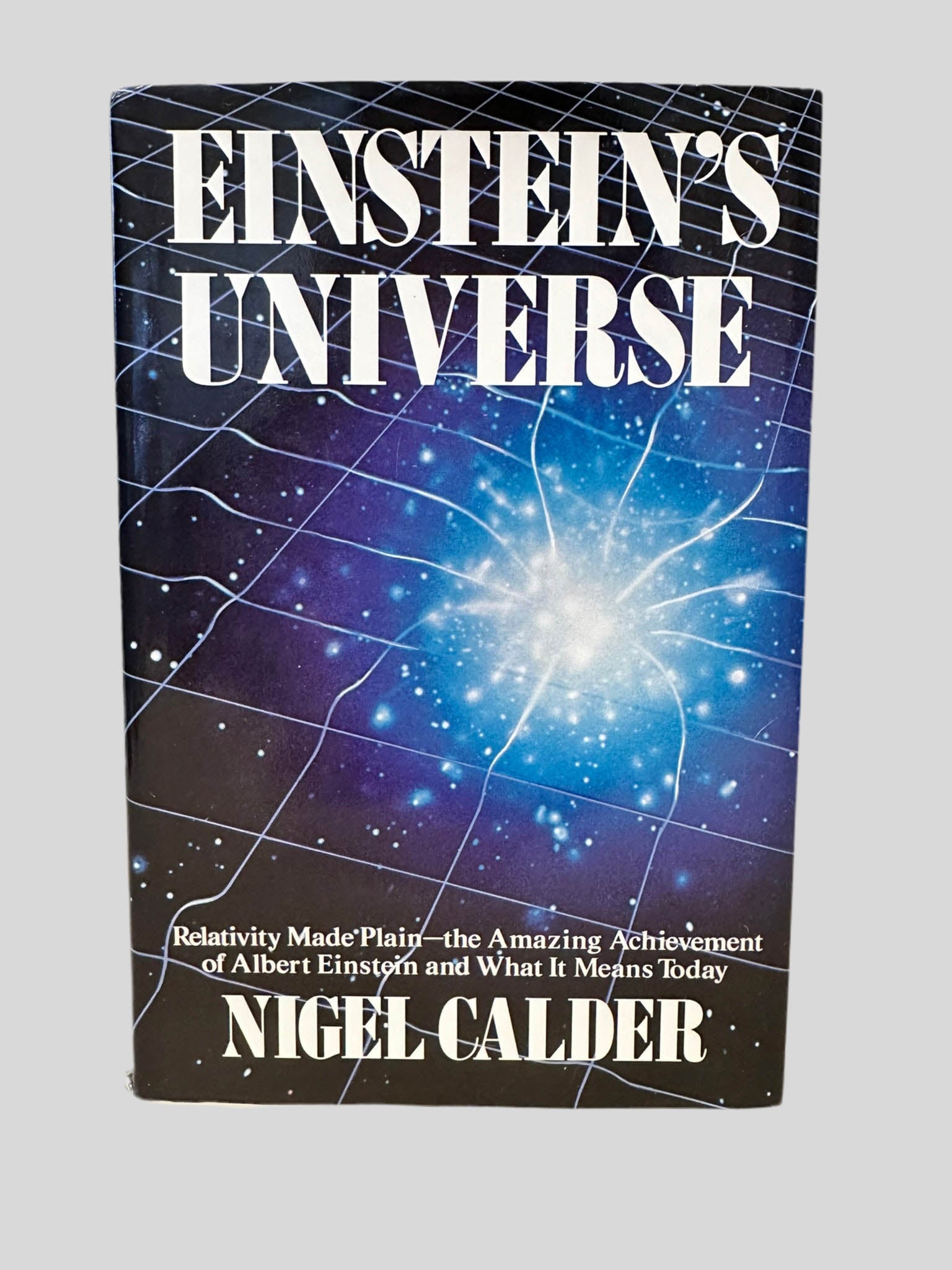Front cover view of Einstein's Universe by Nigel Calder centered on a neutral light gray background. Dust jacket is present. 