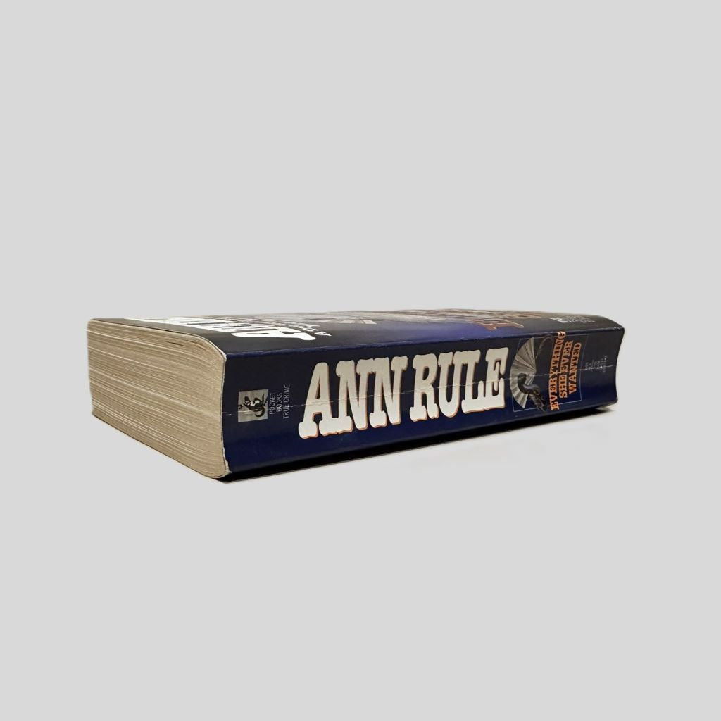 Close-up spine view of Everything She Ever Wanted by Ann Rule centered on a neutral light gray background. Spine shows some creasing.