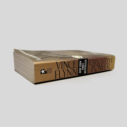Close-up spine view of Executive Power by Vince Flynn centered on a neutral light gray background. Spine is square and shows minimal creasing.