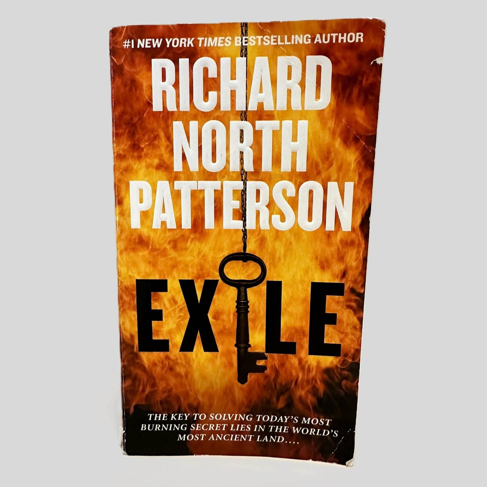 Front cover view of Exile by Richard North Patterson centered on a neutral light gray background. Chipping around the edges of the front cover. Creasing to the top and bottom right corners.