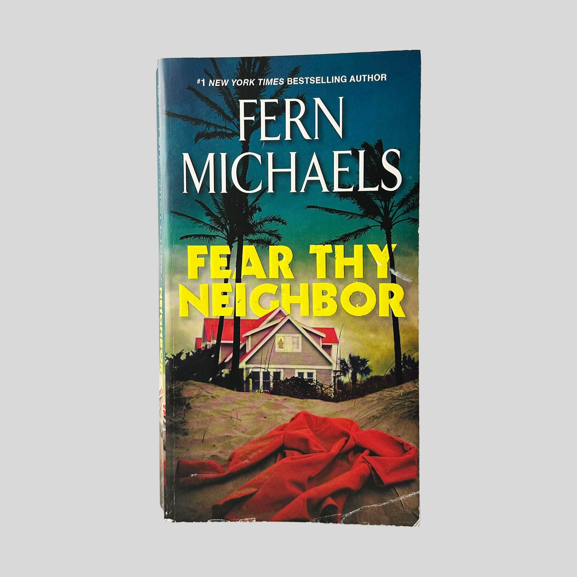Front cover view of Fear Thy Neighbor by Fern Michaels centered on a neutral light gray background. Some chipping and creasing on the bottom edge and bottom left corner.
