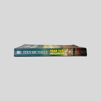 Close-up spine view of Fear Thy Neighbor by Fern Michaels centered on a neutral light gray background. Spine shows creasing. Pages lay flat.