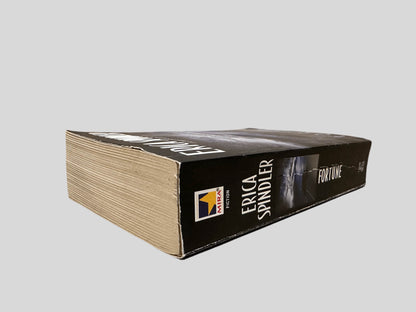 Close-up spine view of Fortune by Erica Spindler centered on a neutral light gray background. Spine is square and shows minimal creasing. Pages lay flat.