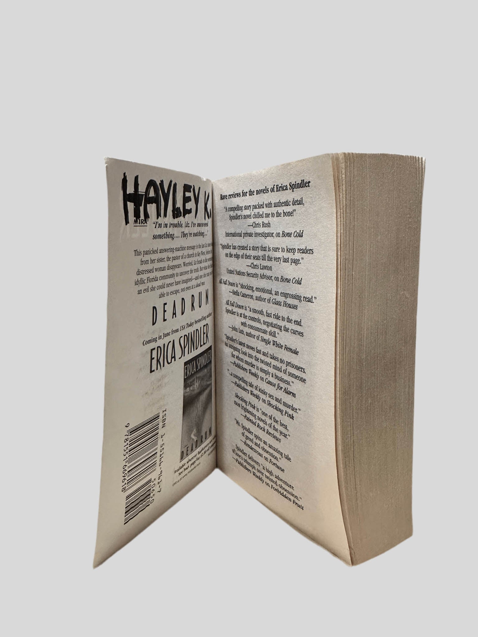 Inside front cover view of Fortune by Erica Spindler centered on a neutral light gray background. On the inside of the cover, a previous owner's name is written in black "HAYLEY K."