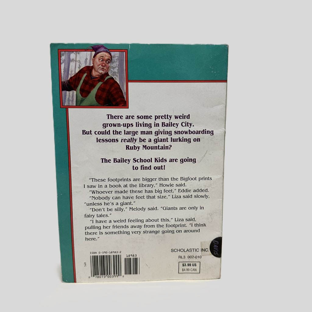 Back cover view of Giants Don't Go Snowboarding by Debbie Dadey and Marcia Thornton Jones centered on a neutral light gray background.  Chipping around the edges of the back cover.