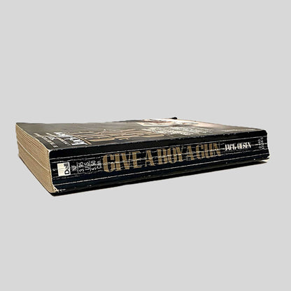 Close-up spine view of Give A Boy A Gun by Jack Olsen centered on a neutral light gray background. Spine shows creasing and bumping.