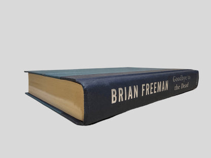 Close-up spine view of Goodbye to the Dead by Brian Freeman centered on a neutral light gray background. Dust jack is not present. Spine shows no creasing. Pages lay flat.