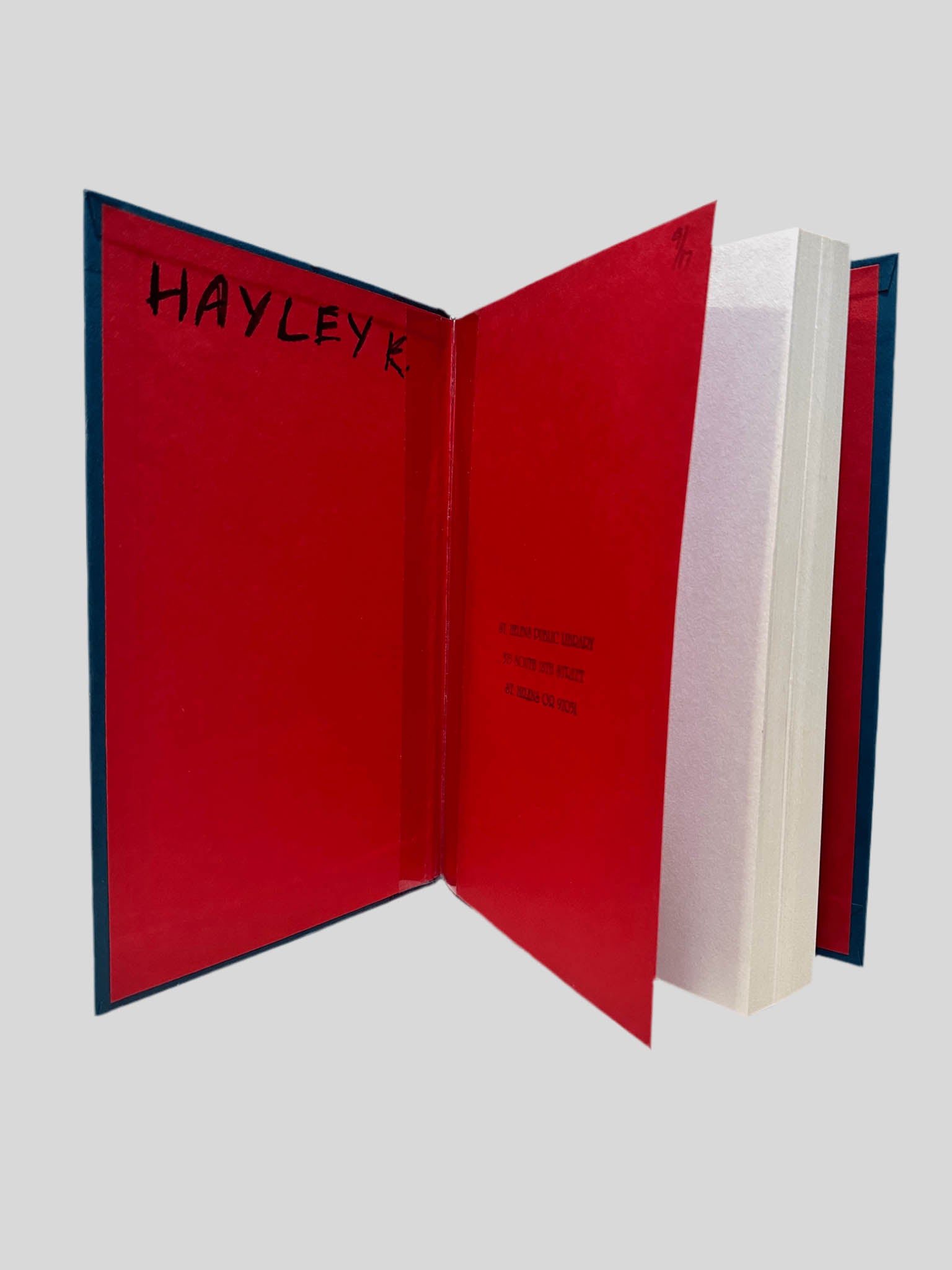 Inside front cover view of Goodbye to the Dead by Brian Freeman centered on a neutral light gray background. Dust jacket is not present. On the inside of the front cover "HAYLEY K. " is written in black ink. The remaining pages are straight and crisp.